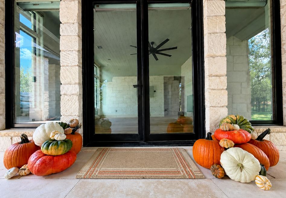 Welcome Collection pumpkins arranged beside a bright glass entry