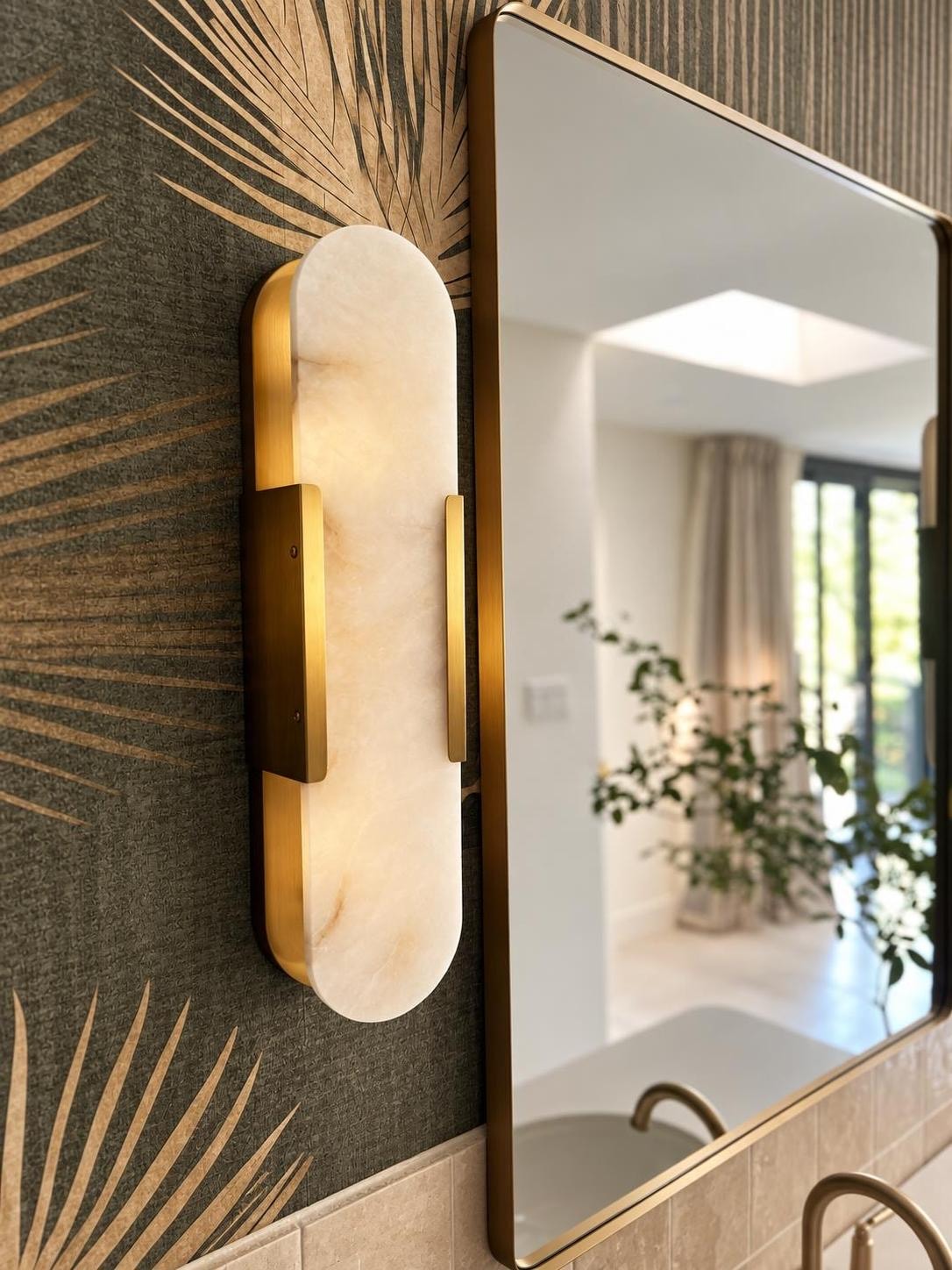 Primary bathroom tub surround detail with a textured ceramic vase, zellige tile, and a wall-mount brass tub filler.