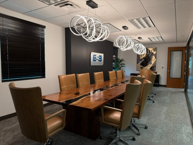 ES3 Office conference room with a long wood table, leather chairs, and sculptural pendant lighting.