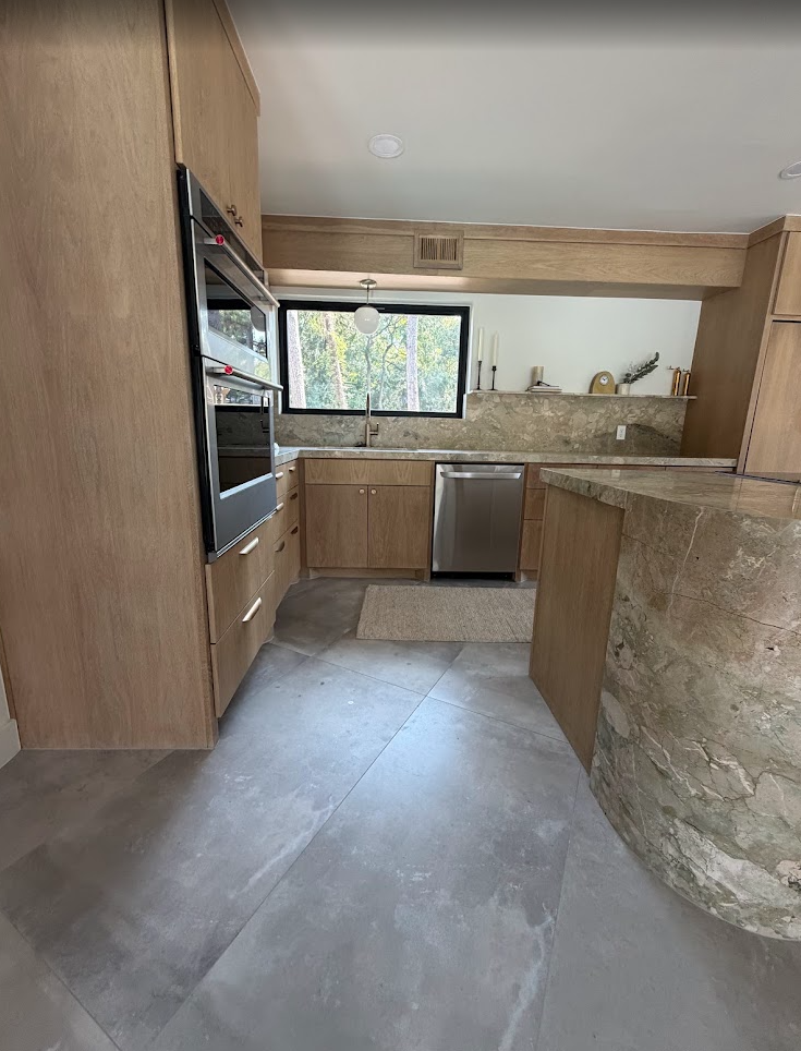 Kitchen workspace with wood cabinetry, stone countertops, and stainless-steel appliances.
